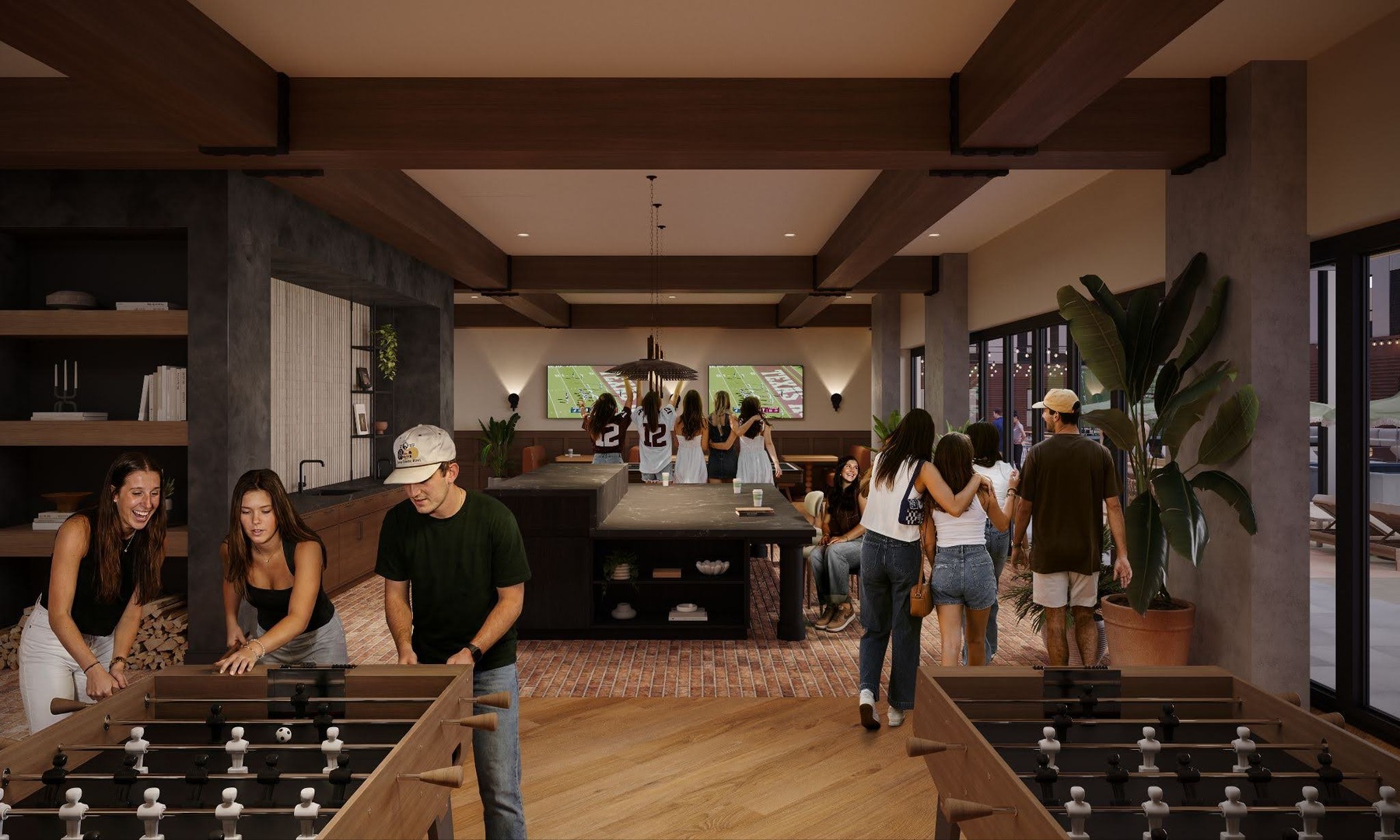 A group of young adults enjoy The Jay’s modern lounge with foosball tables, a large TV showing a football game, comfy couches, and large windows. Some play games, while others talk or watch TV in the lively, casual atmosphere.