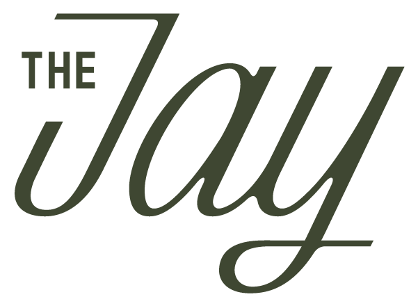 The image shows the words THE Jay in dark green, with THE in uppercase block letters and Jay in large, elegant script font.