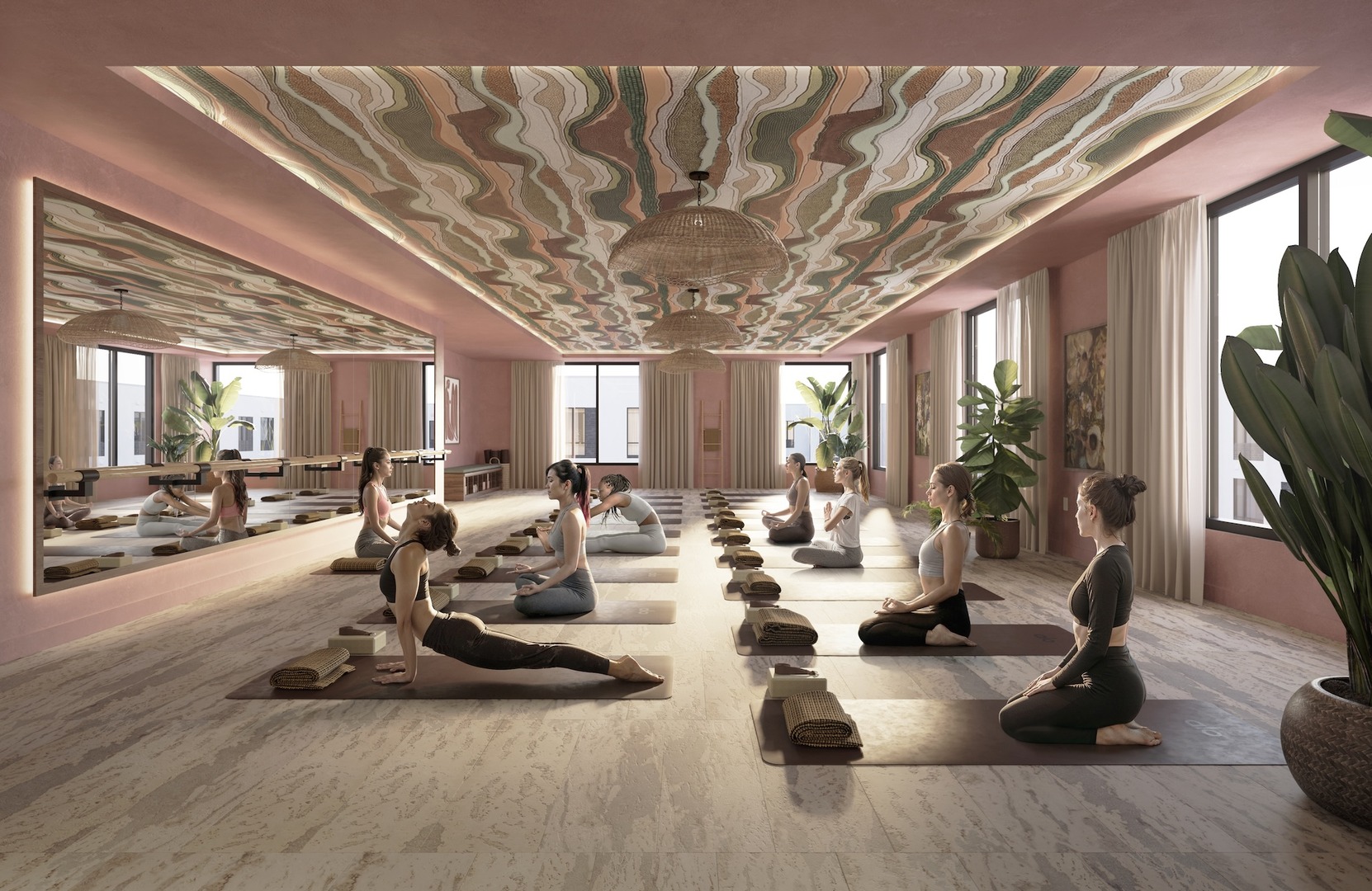 A serene yoga studio with pink walls, large mirrors, and plants. Several people practice yoga poses on mats in rows, with an instructor guiding them. The ceiling features a wavy, colorful design. Sunlight streams through large windows.