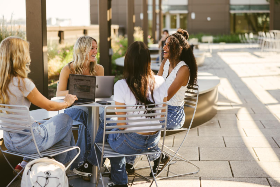 Texas A&M students do work on laptops outside on-campus.