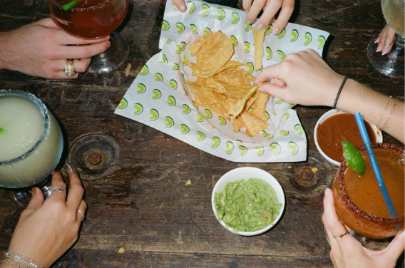 Chips and guacamole shared on wooden tabletop with drinks – The Jay lifestyle photo