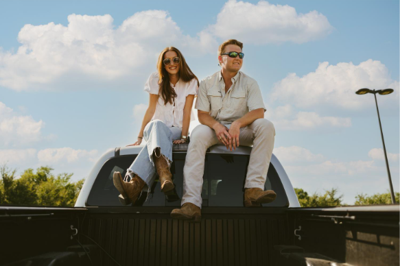 Two people sitting on top of a truck - The Jay lifestyle photo