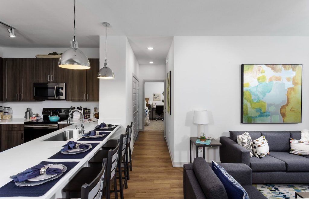Kitchen island and living area at the Hudson College Station Student Apartments.