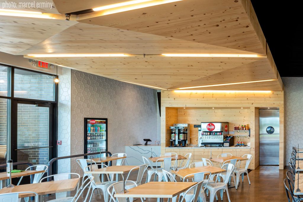 Natural wood an white tile interior with modern lighting at MESS Waffles brunch spot in College Station.