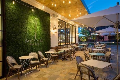 Modern outdoor seating options complimented by vibrant greenery at Sweet Paris brunch spot in College Station.