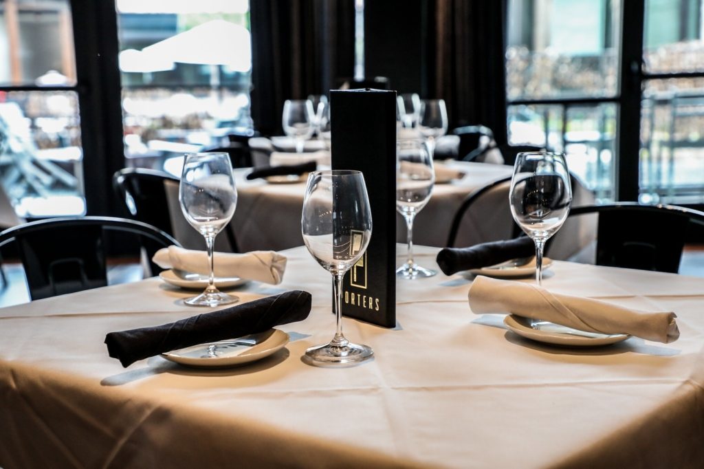 Porters elevated dining experience featuring a fully-set table and sleek wine menu.