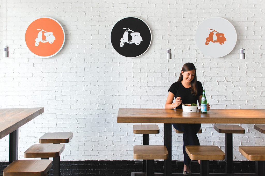 Modern, minimalist interior found inside of Piada with high-top, industrial-style seating.