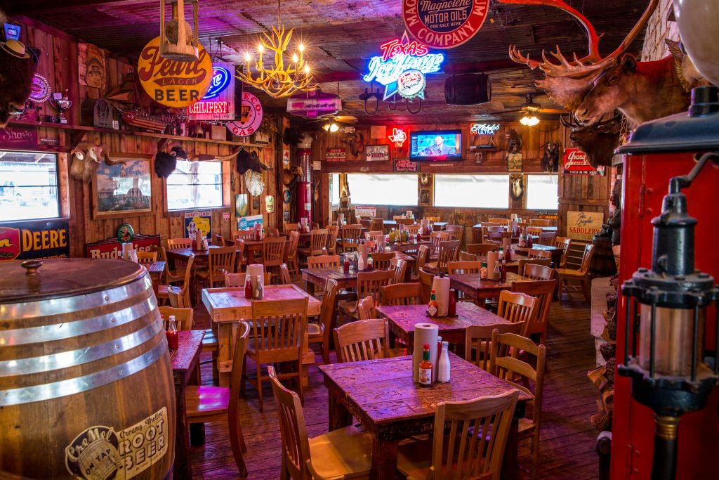 The wooden interior and furniture, mixed with the neon signs truly captures a homey, Texas-style meal at Dixie Chicken in College Station.