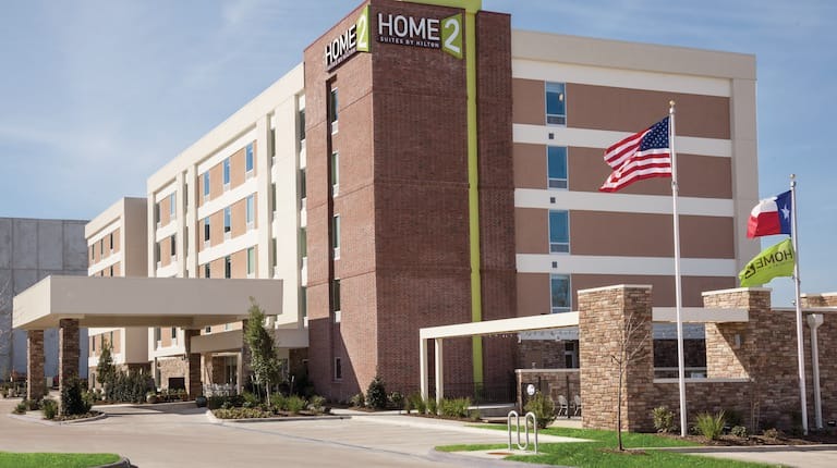 Exterior view of Home2 College Station featuring dark brick and concrete exterior.